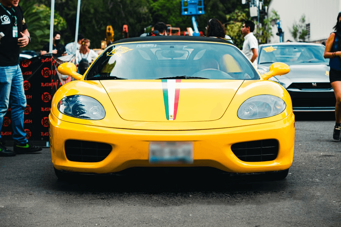 Yellow Ferrari 360 Modena Spider head-on at a car meet, wearing an Italian tricolore stripe down the bonnet