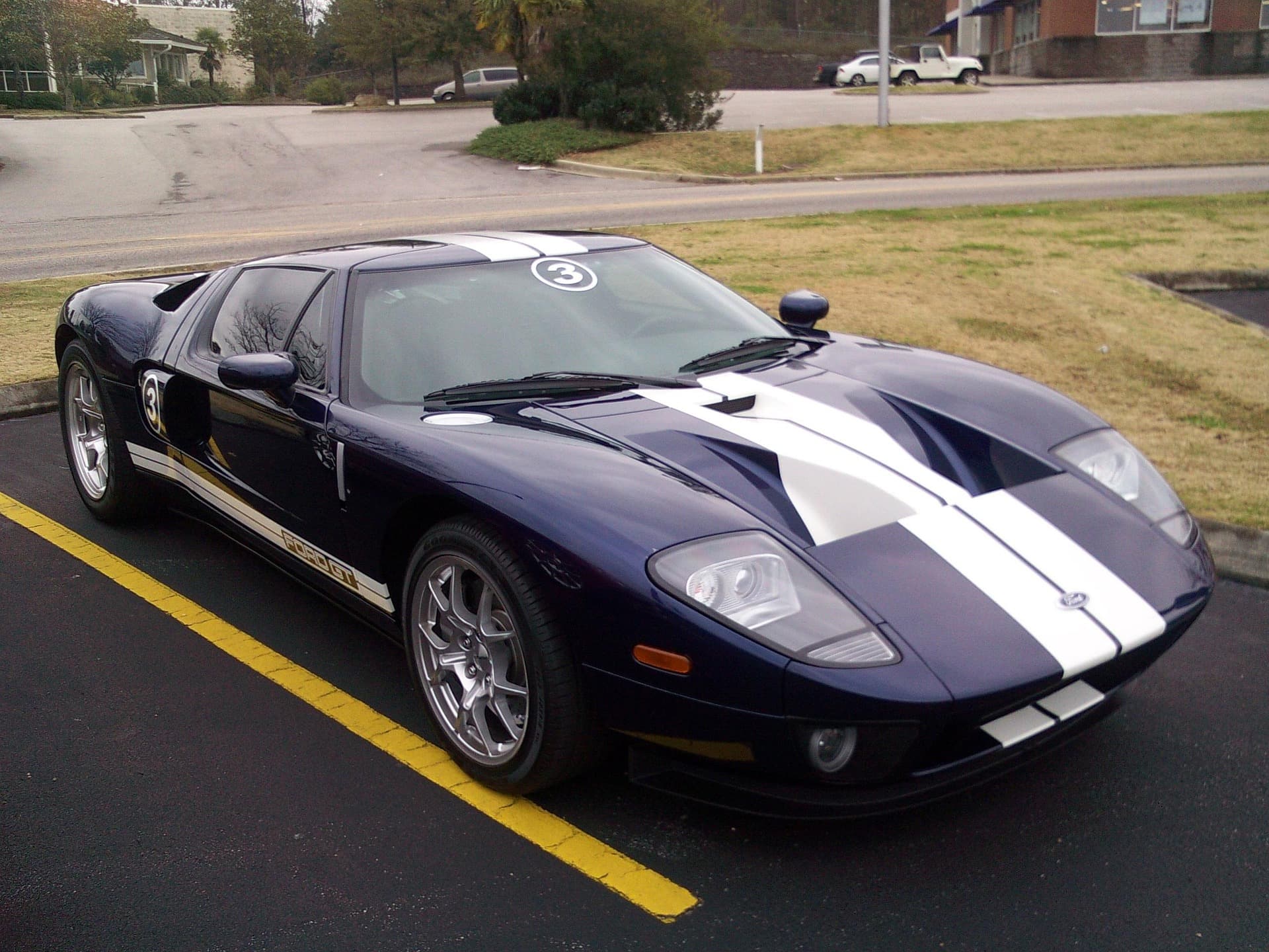 Dark blue 2005–06 Ford GT with white racing stripes and number-3 roundels in a parking lot